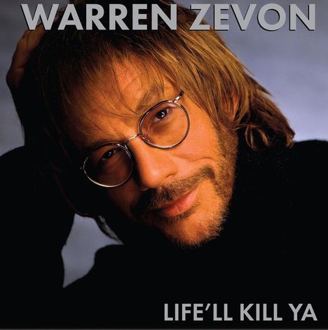 Oben: "WARREN ZEVON", unten: "LIFE'LL KILL YA". Porträt eines Mannes mit Brille und Bart, nachdenklich lächelnd.