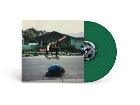 Ein Skateboarder springt über jemanden auf einer Straße. Daneben eine grüne Schallplatte.