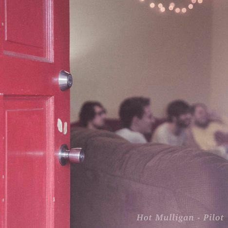 "Hot Mulligan - Pilot" steht unten. Eine rote Tür im Fokus, dahinter unscharf Menschen auf einem Sofa, Lichter im Hintergrund.