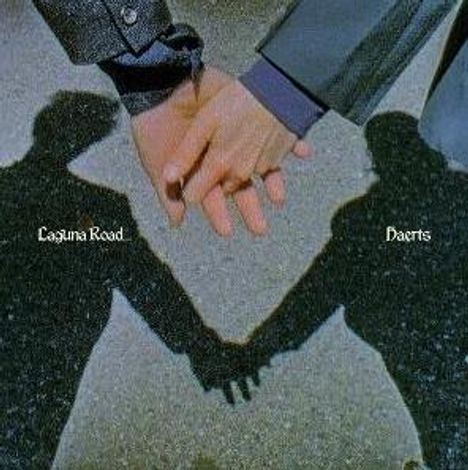 „Laguna Road”, „Haerts“. Zwei Personen halten sich an der Hand, ihre Schatten sind auf dem Boden zu sehen.