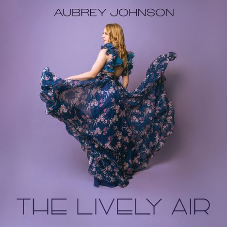 "AUBREY JOHNSON" und "THE LIVELY AIR". Eine Frau in einem blumenbedruckten, fließenden Kleid auf violettem Hintergrund.