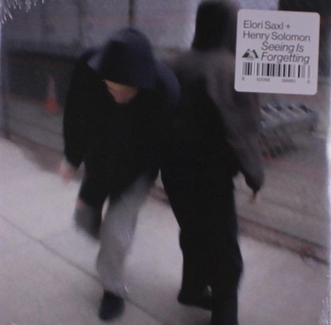 Aufkleber mit „Elori Saxl + Henry Solomon – Seeing Is Forgetting“. Zwei Personen in dunkler Kleidung, unscharf, gehen.