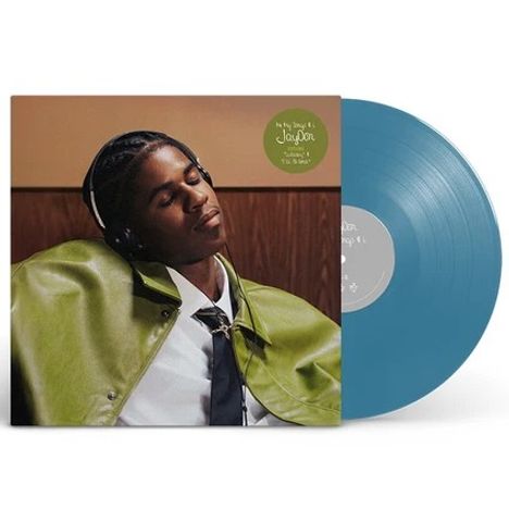 Aufkleber: "In My Songs ft. JayDon. Listening to 'I'll Be Gone'". Person trägt Kopfhörer und grüne Jacke. Vinylplatte ist blau.