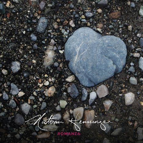 Unterschrift: "Romanza" und weiße handschriftliche Signatur über Kieselsteinen, darunter ein herzförmiger Stein.