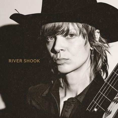 Der Text "RIVER SHOOK" ist zu sehen. Eine Person mit Cowboyhut und Gitarre blickt ernst in die Kamera.