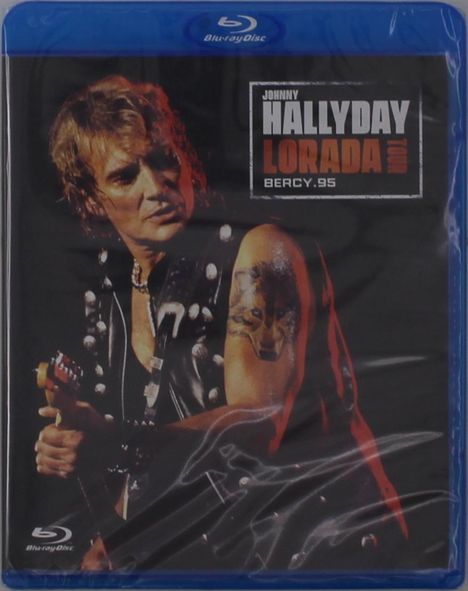 Texte: JOHNNY HALLYDAY, LORADA TOUR, BERCY.95. Mann spielt Gitarre, trägt Lederweste mit Nieten, Tattoo am Arm.