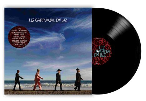 „U2 Carnaval de Luz“; Kreistext: „The new studio album... Dolly Parton“. Vier Personen gehen am Strand, Himmel im Hintergrund.