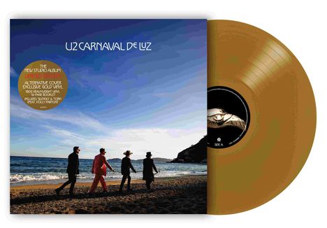 "U2 CARNAVAL DE LUZ" steht vor einem blauen Himmel. Vier Personen spazieren an einem Strand entlang.