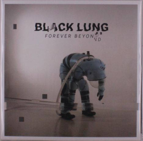 „BLACK LUNG“, „FOREVER BEYOND“. Ein gebückter Mensch in einem hellblauen Anzug mit Schläuchen in einem leeren Raum.