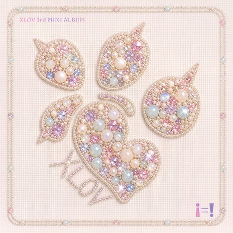 Text: "XLOV 3rd MINI ALBUM" und "XLOV". Design: Herz und Blätter, verziert mit Perlen und bunten Kristallen.