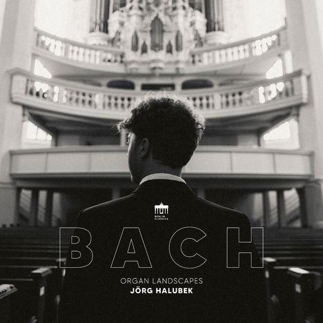 BACH, ORGAN LANDSCAPES, JÖRG HALUBEK. Ein Mann in einem Anzug steht vor einer großen Kirchenorgel.