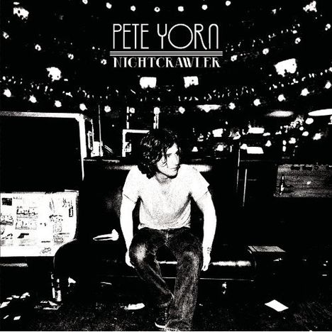 Text: "Pete Yorn, Nightcrawler". Ein Mann sitzt nachdenklich auf einem Sofa in einem kontrastreichen Schwarz-Weiß-Stil.