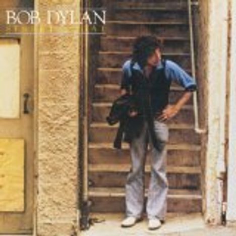 Text oben: "BOB DYLAN STREET-LEGAL". Person steht auf einer Treppe, hält eine schwarze Jacke, schaut zur Seite.