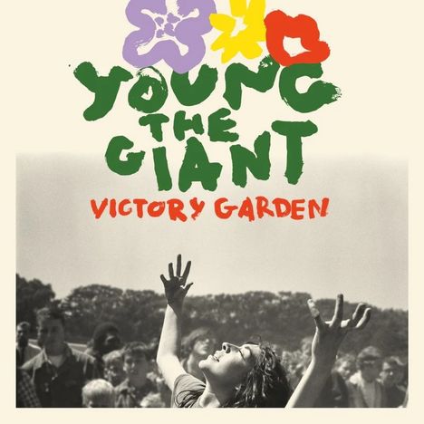 "YOUNG THE GIANT VICTORY GARDEN." Eine schwarz-weiße Szene mit einer Person in freudiger Pose, Arme nach oben.