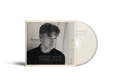 Texte: "Morten Harket", "Human Grace". Schwarz-weißes Porträt eines nachdenklichen Mannes vor einer Holzwand.