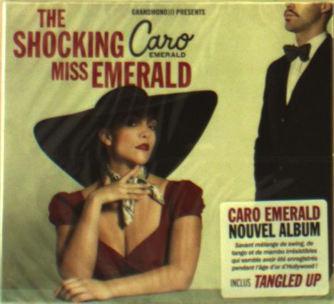Text: "THE SHOCKING MISS EMERALD", "CARO EMERALD NOUVEL ALBUM INCLUT TANGLED UP". Frau mit großem Hut, Mann im Anzug.