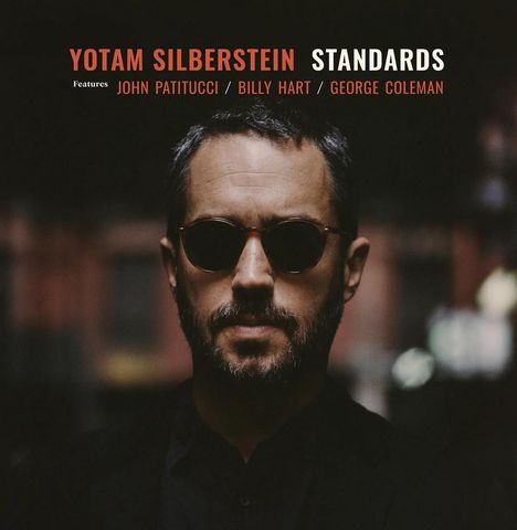 "Yotam Silberstein Standards" in roter und weißer Schrift, dunkler Hintergrund mit einem Mann in Sonnenbrille im Vordergrund.