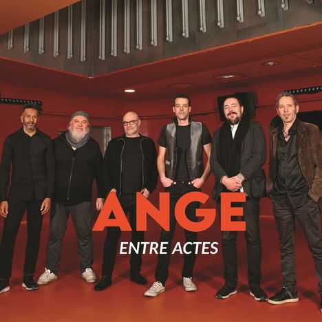 „ANGE ENTRE ACTES“. Sechs Männer stehen lächelnd vor einer roten Wand.