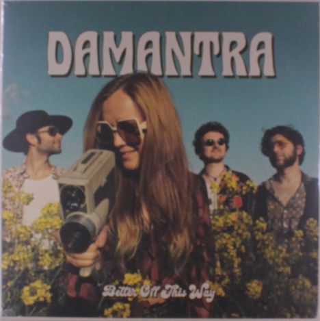 „DAMANTRA“ oben, „Better Off This Way“ unten. Eine Person mit Kamera vor Blumen, drei weitere Personen im Hintergrund.