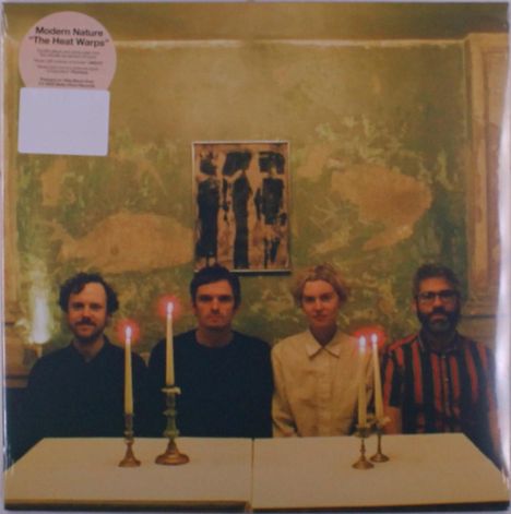 Text: "Modern Nature 'The Heat Warps'". Vier Personen, zwei Kerzen, grüne Wand mit abstraktem Bild.