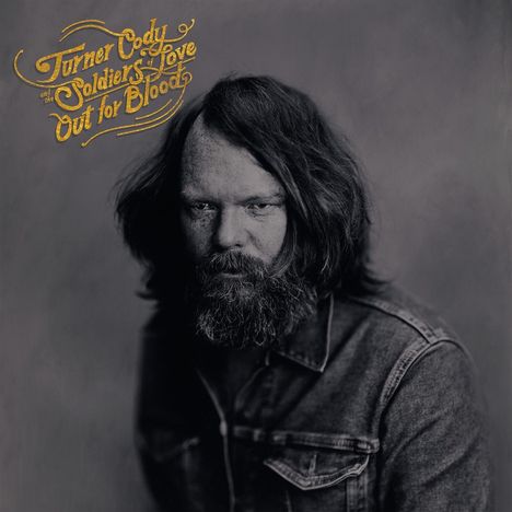 „Turner Cody and the Soldiers of Love: Out for Blood“. Ein bärtiger Mann in Jeansjacke schaut direkt nach vorne.