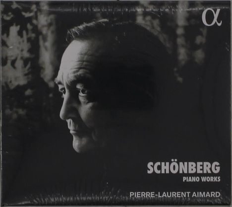 "Schönberg Piano Works, Pierre-Laurent Aimard" steht unten. Schwarz-Weiß-Porträt eines nach links blickenden Mannes. Logo oben rechts.