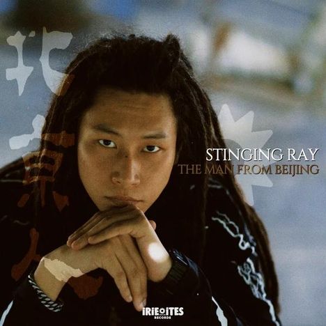 „STINGING RAY - THE MAN FROM BEIJING“. Ein junger Mann sitzt mit gefalteten Händen vor seinem Gesicht, der Hintergrund ist unscharf.