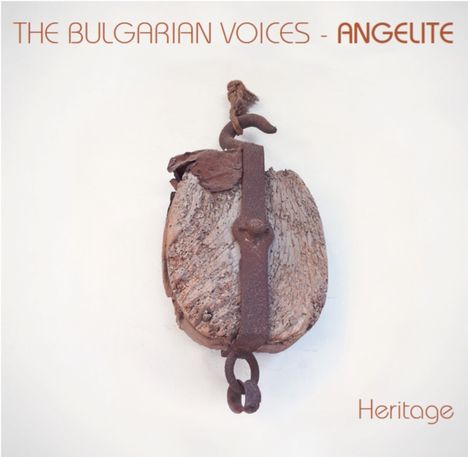 Text: "THE BULGARIAN VOICES - ANGELITE", "Heritage". Rustikales Holzobjekt mit Metallbügel und Haken.