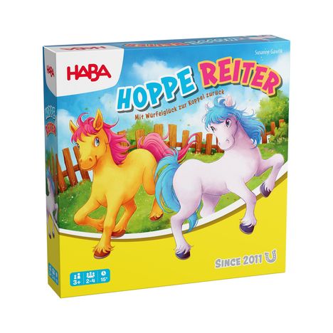 „HABA“ und „HOPPE REITER“. Zwei bunte Ponys, gelbes und weißes, vor Holzzaun und blauen Himmel. Verpackung.