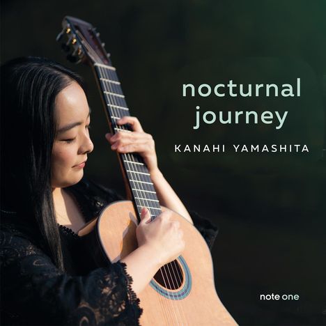 „nocturnal journey, Kanahi Yamashita, note one“. Eine Frau spielt eine klassische Gitarre im natürlichen Licht.