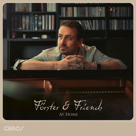 „Förster & Friends“, „At Home“. Ein Mann lehnt nachdenklich an einem Klavier, im Hintergrund Bücherregale.