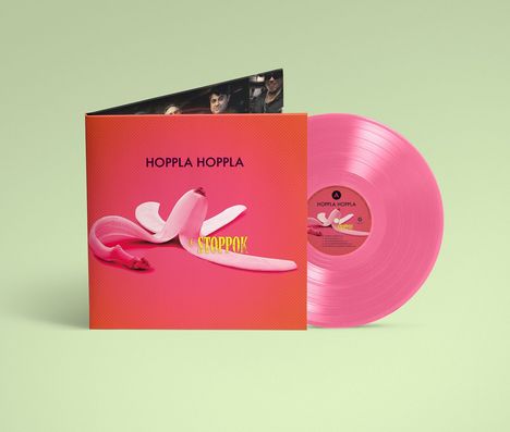 „HOPPLA HOPPLA“ und „STOPPOK“ in Gelb auf orangem Cover mit rosa Banane; daneben pinke Vinyl-Schallplatte.