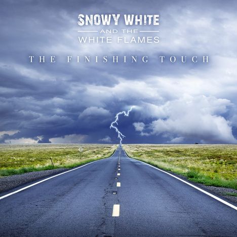 "Snowy White and the White Flames: The Finishing Touch." Eine lange Straße führt in einen bewölkten Himmel mit Blitz.