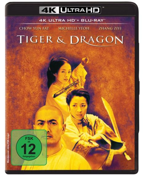 "Tiger & Dragon" in weißen Buchstaben, darunter drei Personen mit Schwertern, orangefarbener Hintergrund, FSK 12 Logo.