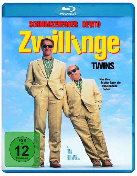 Text: "Schwarzenegger DeVito Zwillinge Twins Nur ihre Mutter kann sie auseinanderhalten. Ein Ivan Reitman Film." Zwei Männer in Anzügen vor blauem Himmel.