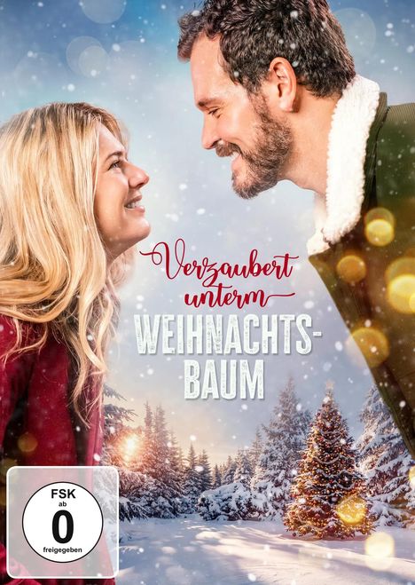 Titel: "Verzaubert unterm Weihnachtsbaum". Zwei Menschen lächeln sich an. Schneebedeckte Bäume im Hintergrund.