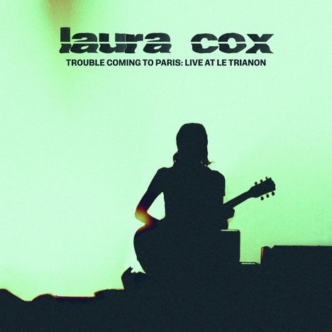 Text: "laura cox" und "TROUBLE COMING TO PARIS: LIVE AT LE TRIANON". Silhouette einer Gitarristin vor grünem Hintergrund.