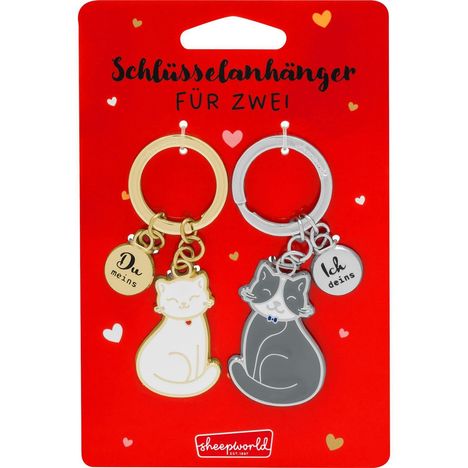 „Schlüsselanhänger für zwei“ in großer Schrift. Zwei Katzenschlüsselanhänger: „Du meins“ und „Ich deins“ auf rotem Hintergrund.