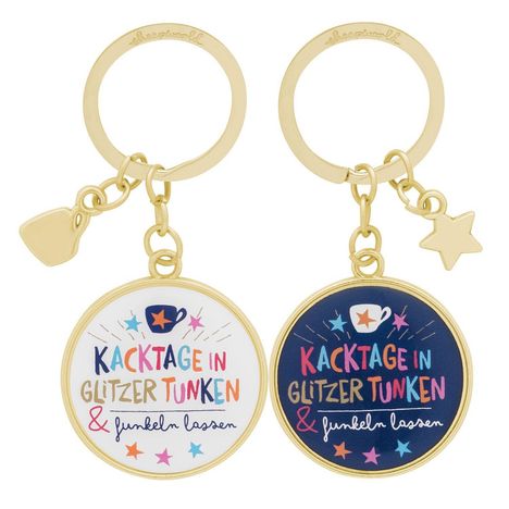 Zwei Schlüsselanhänger mit dem Text: "Kacktage in Glitzer tunken & funkeln lassen." Bunte Schrift und Sterne.