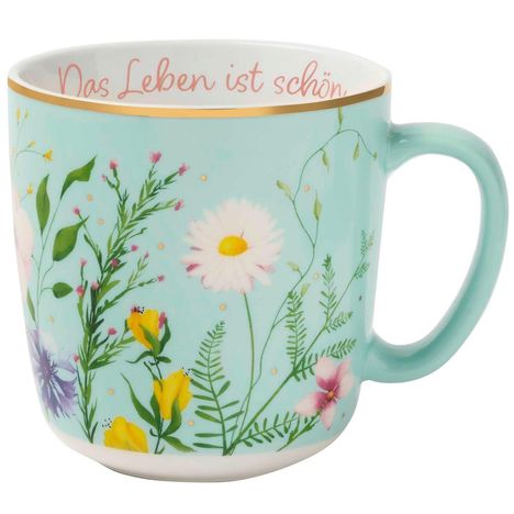„Das Leben ist schön“ in rosa Schrift auf einer pastellblauen Tasse mit bunten Blumenillustrationen.