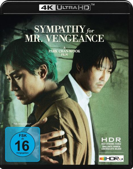 Text: "Sympathy for Mr. Vengeance", "A Park Chan-wook Film", FSK 16. Zwei Männer in enger Umarmung mit ernsten Gesichtern.