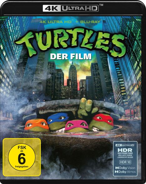 "TURTLES DER FILM", vier maskierte Schildkröten tauchen aus einem Kanaldeckel auf, umgeben von Wolkenkratzern.