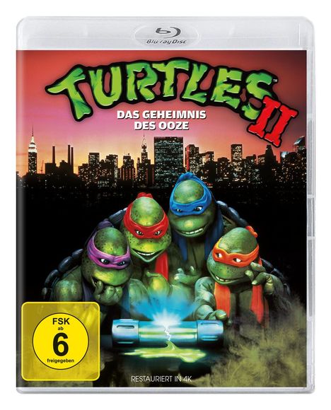 "Turtles II: Das Geheimnis des Ooze" und "FSK ab 6 freigegeben". Vier Schildkröten mit Masken über einer leuchtenden Substanz.