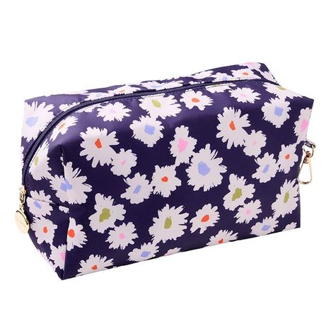 Eine lilafarbene Kosmetiktasche, bedruckt mit weißen Blumenmotiven in verschiedenen Pastellfarben.