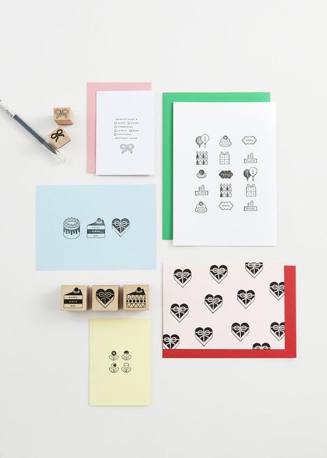Karten, Stempel und Umschläge in Pastelltönen mit Geburtstagsmotiven und symbolisierten Herzen angeordnet auf einem weißen Hintergrund.