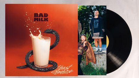 "BAD MILK" und "Meast Machine" in fetter Schrift. Ein Glas Milch mit Schlange, daneben zwei Personen in auffälliger Kleidung.