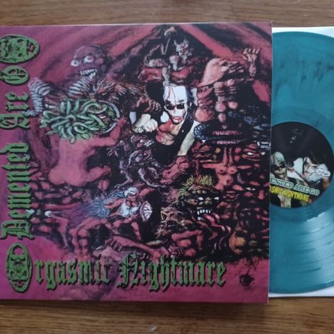 Text: "Demented Are Go", "Orgasmic Nightmare". Eine gruselige Illustration mit deformierten Gestalten und düsteren Farben.