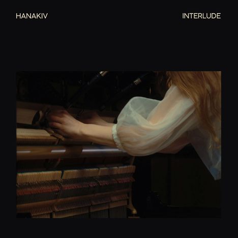 Texte: "HANAKIV", "INTERLUDE". Eine Person bedient das Innenleben eines Pianos mit konzentrierten Händen.