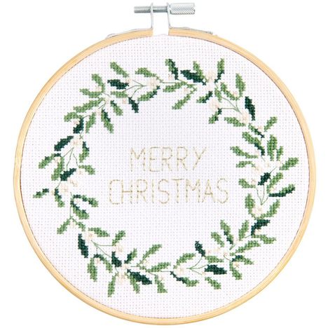 "Merry Christmas" in goldener Schrift innerhalb eines grünen Blätterkranzes, Kreuzstichstickerei in Holzrahmen.