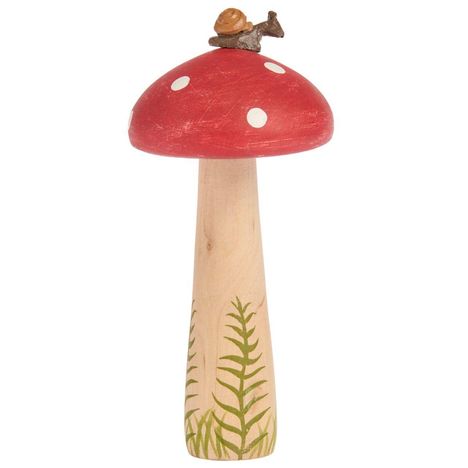 Holzfigur eines Fliegenpilzes mit rotem Hut und weißen Punkten, dekoriert mit Farnen und einer Schnecke obendrauf.